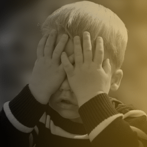 Photo of child covering his face with his hands