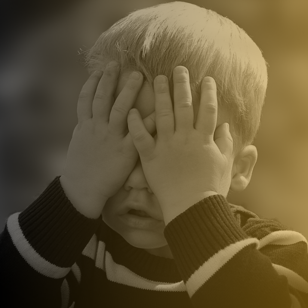 Photo of child covering his face with his hands